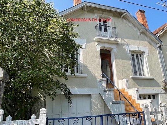 Maison avec jardin et deux garages.